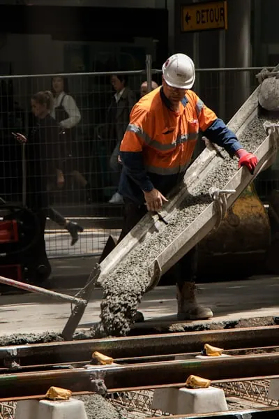 Worker pouring cement on site